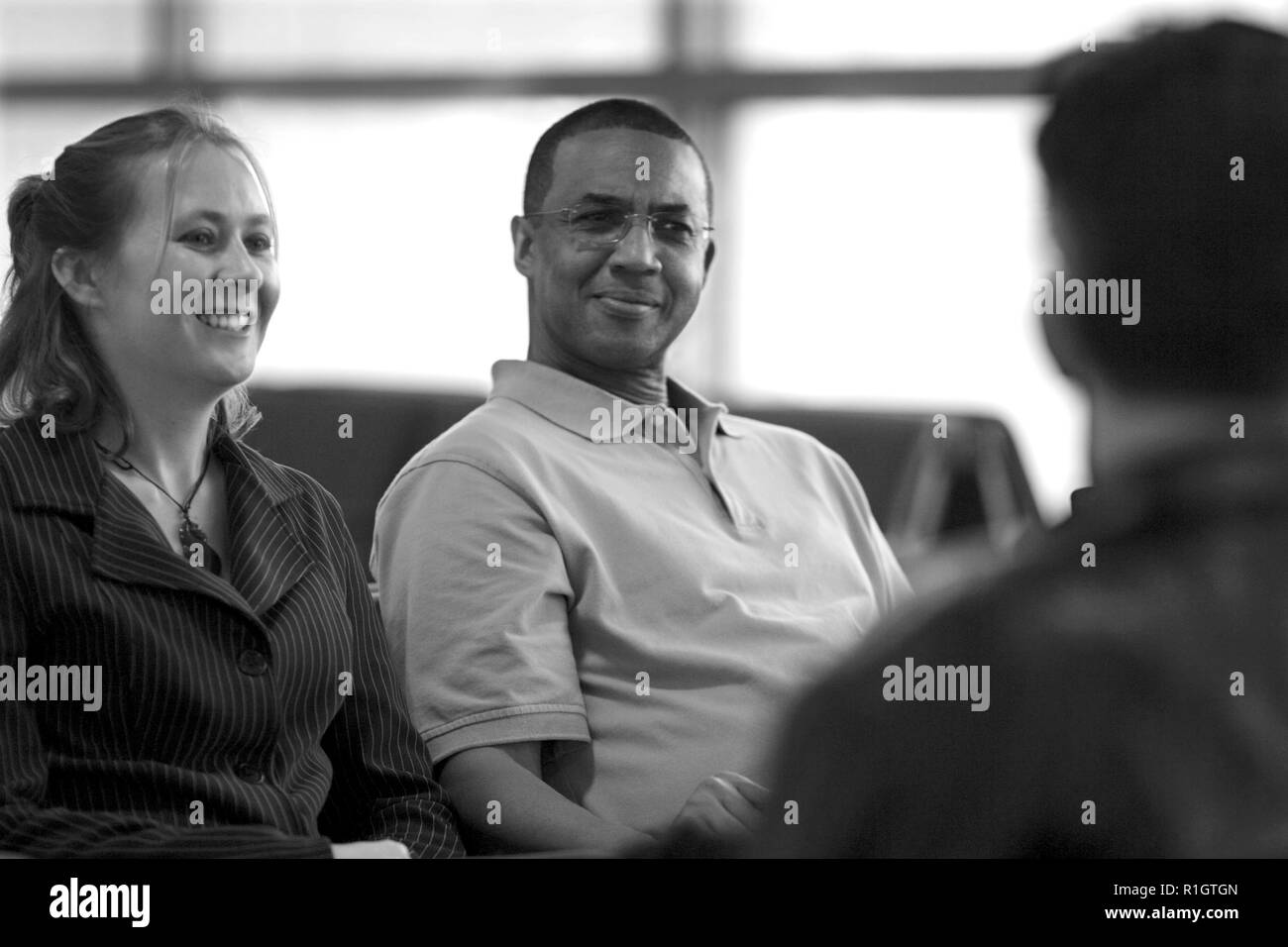 Die Leute sitzen und Reden in einem Flughafen Stockfoto