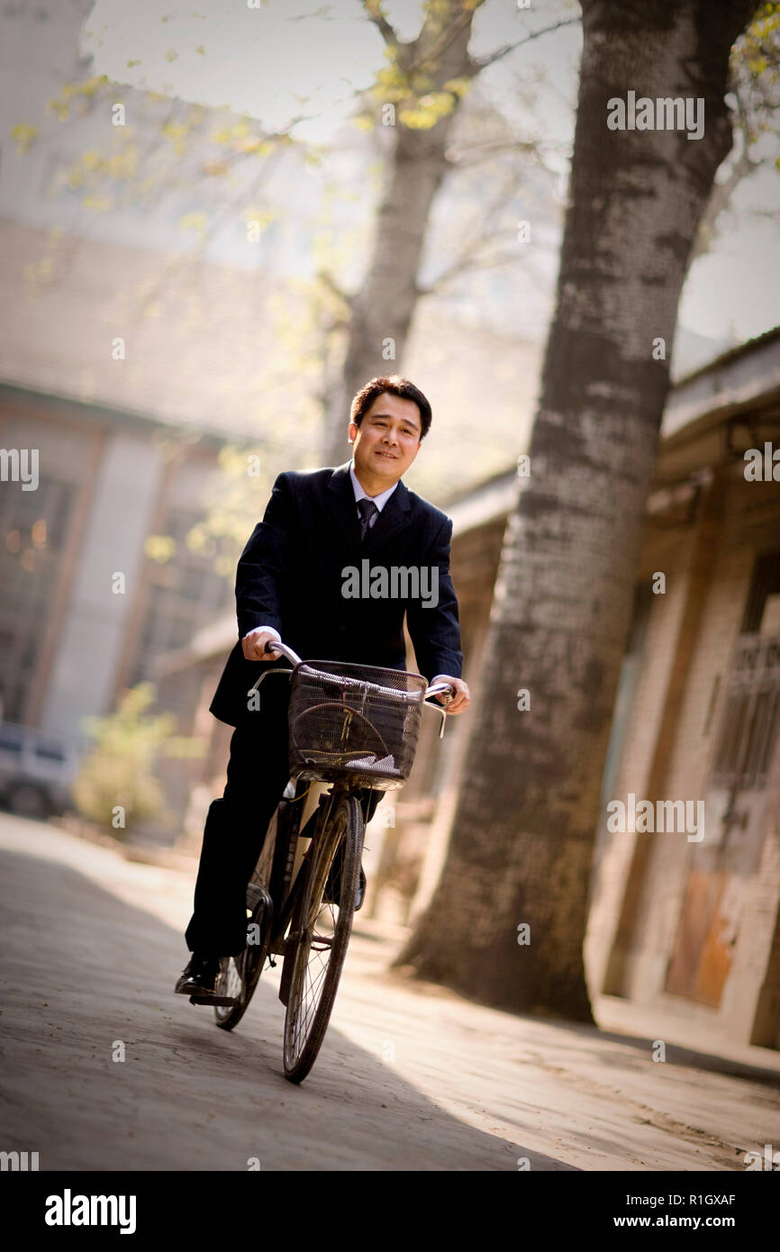 Mitte - Erwachsene business Mann auf einem Fahrrad die Straße entlang. Stockfoto