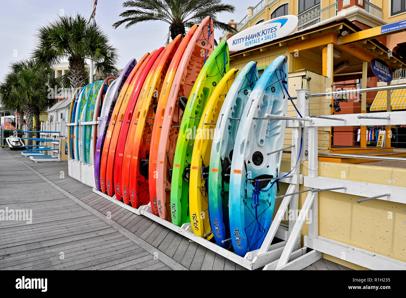 Bunte Paddle Boards und Surfbretter aufgereiht in einem Regal für Vermietung oder Verkauf an HarborWalk Marina, Destin Florida, USA. Stockfoto
