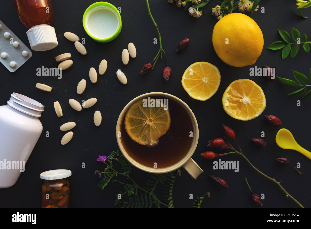 Pflanzliche gegenüber konventionellen Medizin Konzept, Tasse Tee und Zitrone Obst oder Pillen und Medikamente Stockfoto