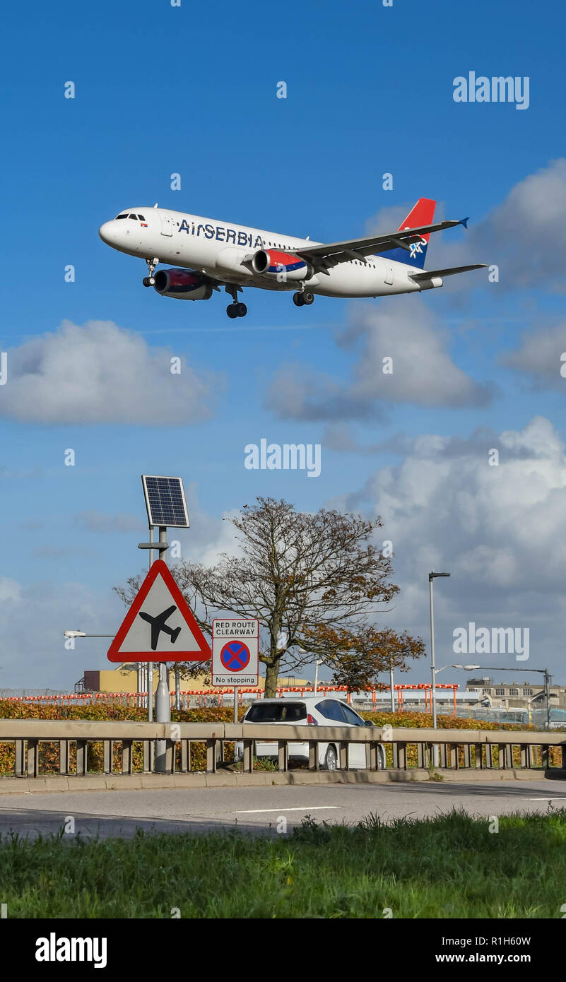LONDON, ENGLAND - NOVEMBER 2018: Schild auf der 30 Straße am Flughafen London Heathrow Autofahrer rechtzeitig von niedrig fliegenden Flugzeugen. Im Hintergrund ist ein Stockfoto