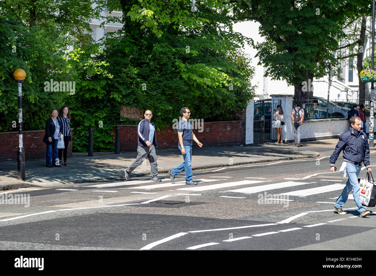 Touristen gehen über den berühmten Abbey Road, London, Vereinigtes Königreich Stockfoto