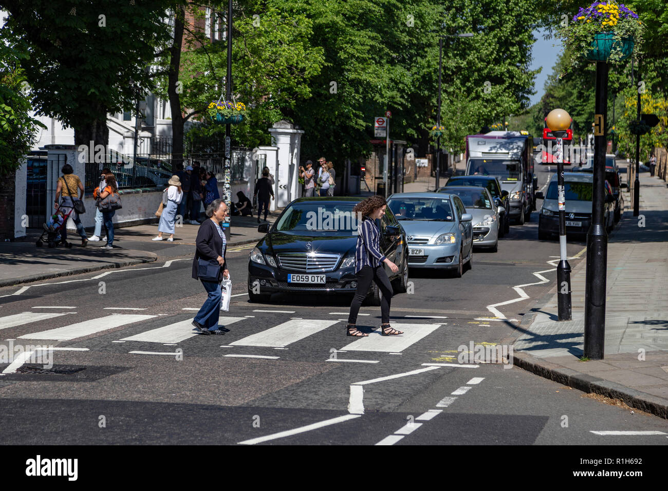 Touristen gehen über den berühmten Abbey Road, London, Vereinigtes Königreich Stockfoto