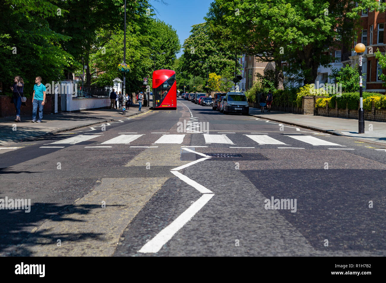 Touristen gehen über den berühmten Abbey Road, London, Vereinigtes Königreich Stockfoto