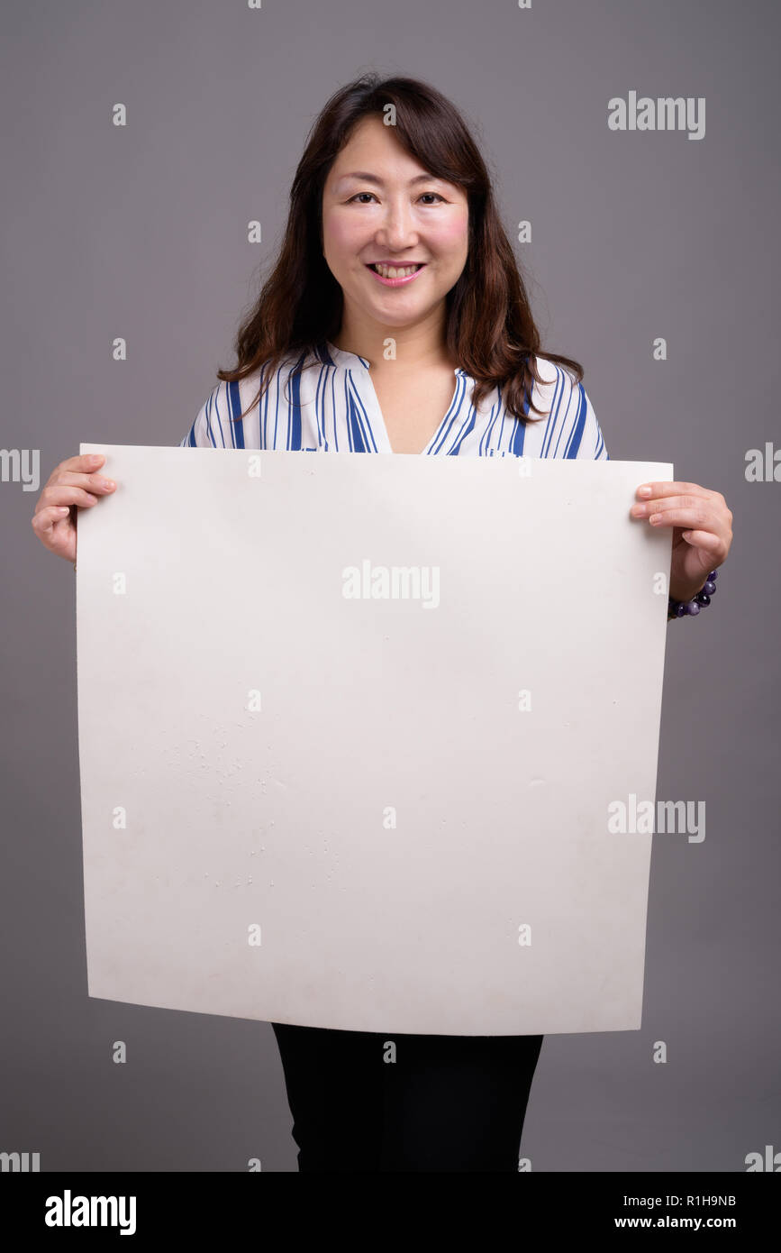 Reife japanische Geschäftsfrau Holding leere weiße Kopie Raum Stockfoto