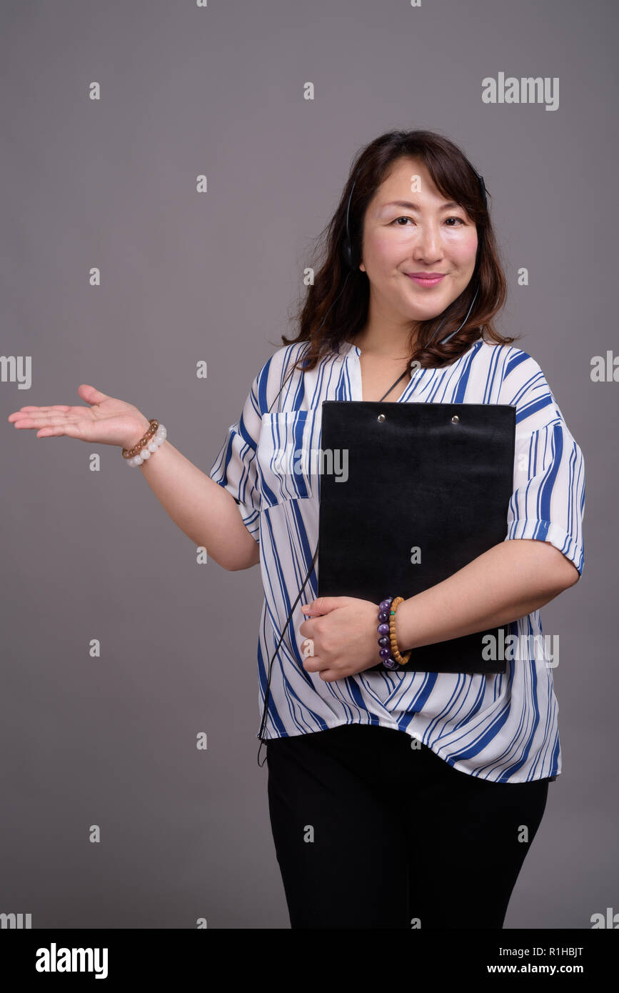 Portrait von Ausgereiften asiatischen Geschäftsfrau holding Zwischenablage Stockfoto