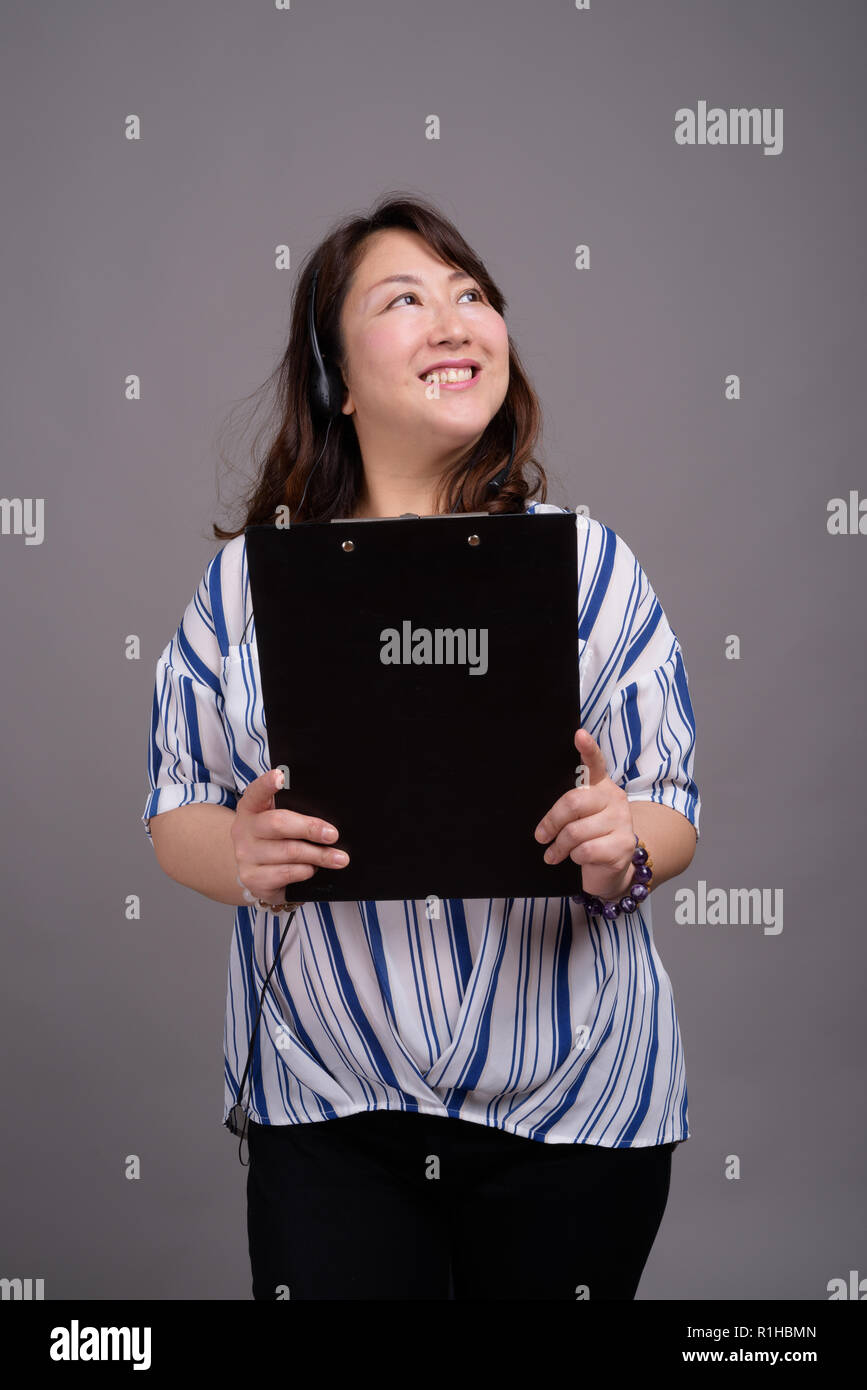 Portrait von Ausgereiften asiatischen Geschäftsfrau holding Zwischenablage Stockfoto