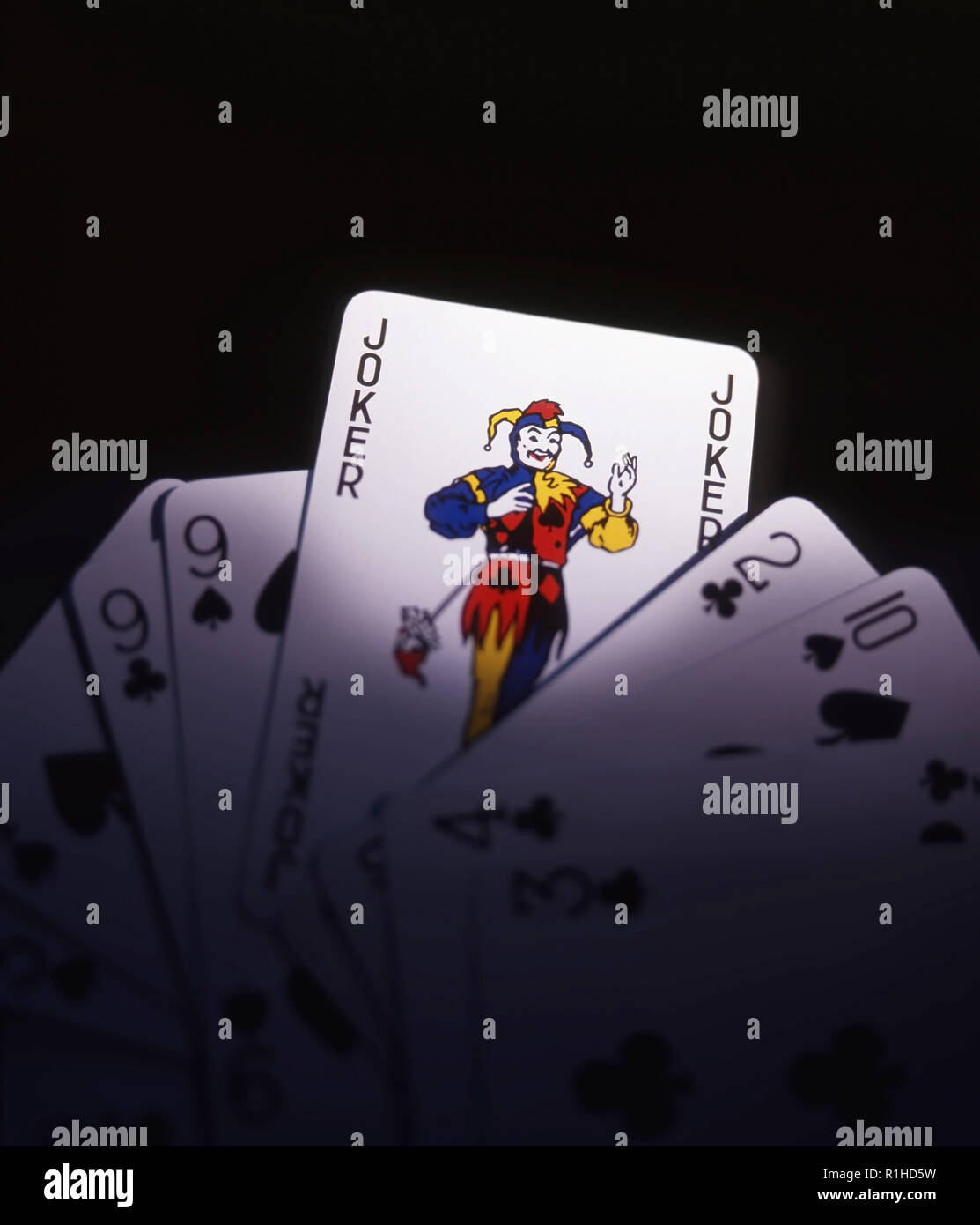 Die Karten zeigen eine Joker vor einem dunklen Hintergrund. Stockfoto