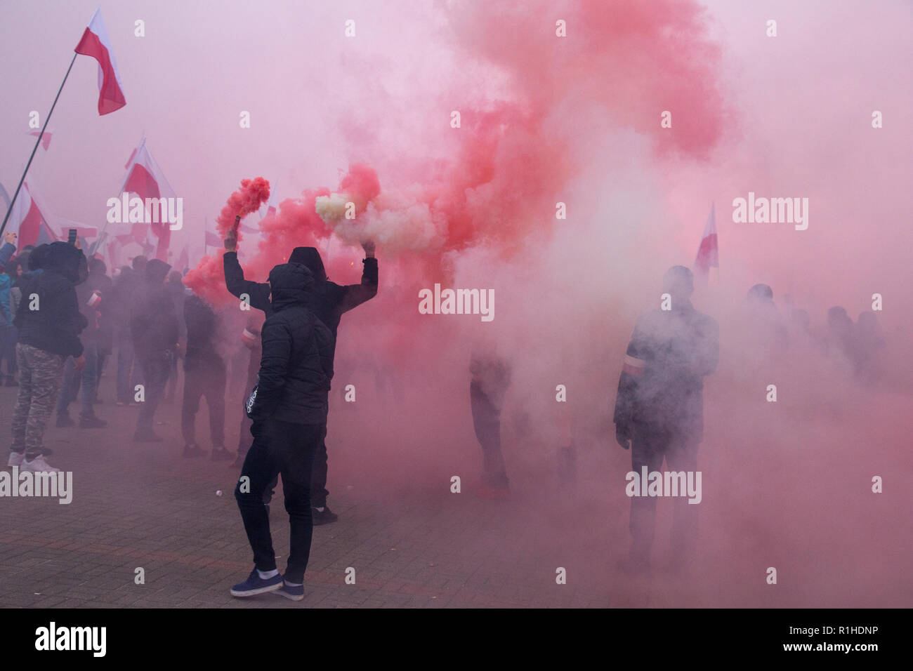 Warschau, Polen, 11. November 2018: Mann mit roten und weißen Rauchen flare Stockfoto