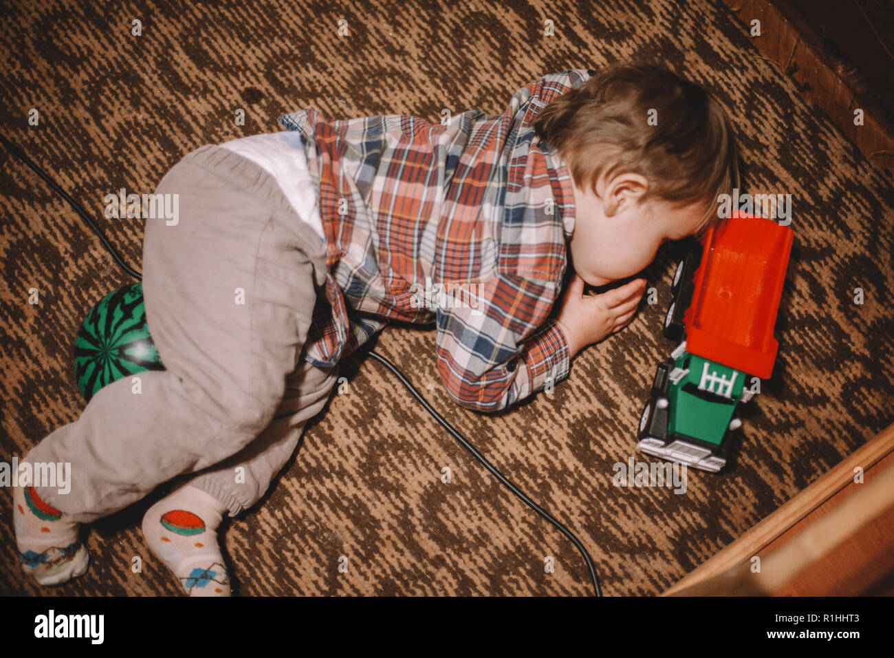 Verspieltes Baby auf dem Boden liegend zu Hause Stockfoto