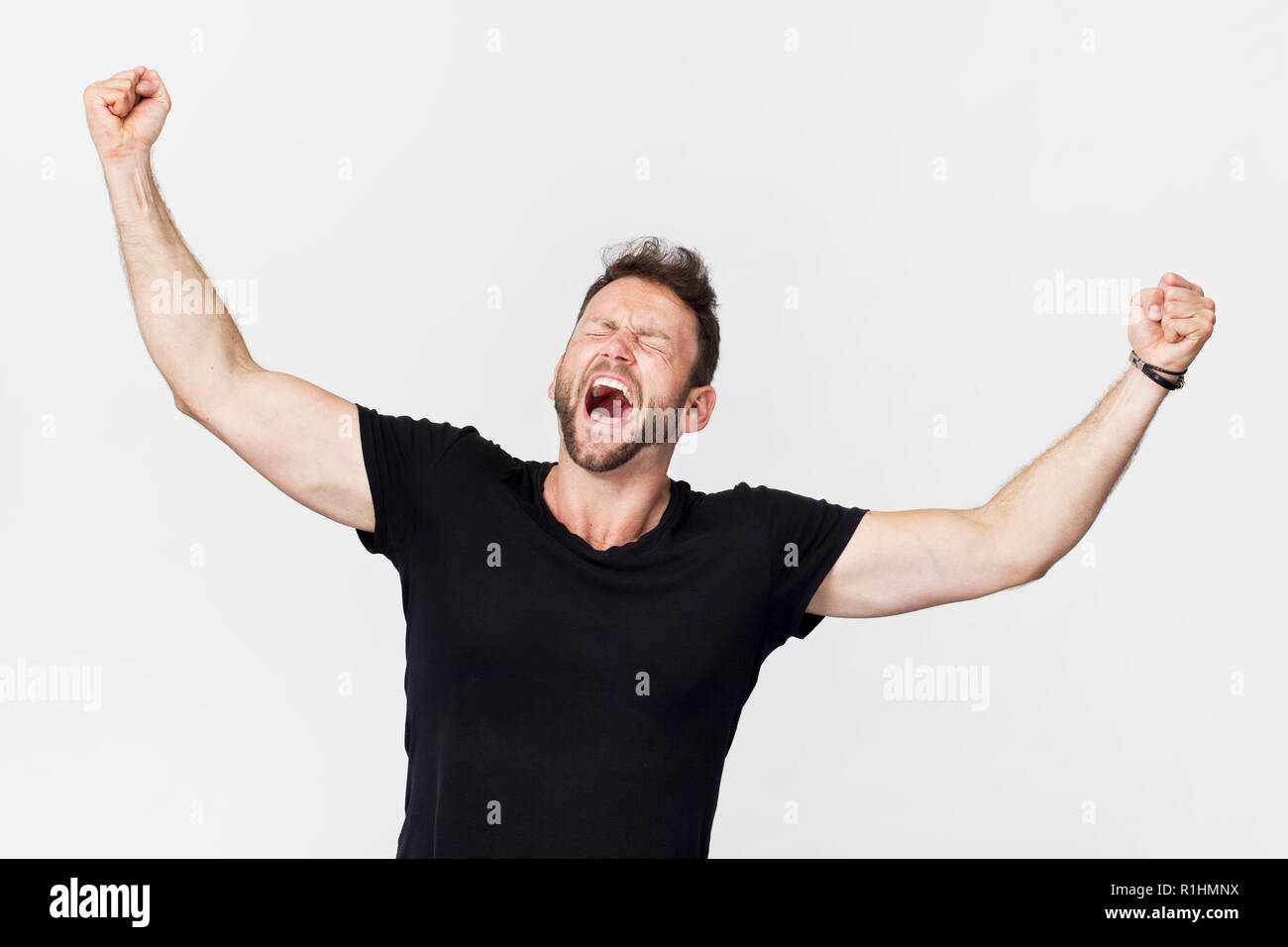 Sieg Geste. Erwachsenen Mann in schwarzen T-Shirt studio Shot, isoliert auf weißem Stockfoto