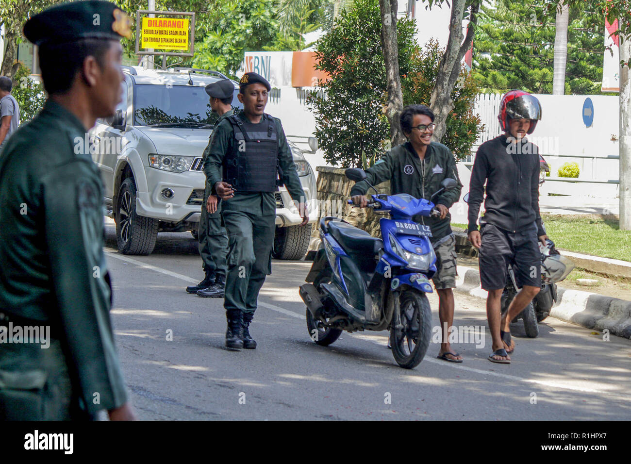 Die islamische Scharia Polizeioffizier (Wilayatul Hisbah) gesehen stoppen ein Kraftfahrer einen Kurzschluß tragen während des routinemäßigen Razzien in Lhokseumawe. Die islamische Scharia Polizisten (Wilayatul Hisbah) bieten sarongs Für diejenigen, die die islamische Scharia durch Gewalt in der Stadt Lhokseumawe verletzt, Aceh ist die einzige Provinz in Indonesien mit der größten Bevölkerung von Muslimen in der Welt, der die islamische Scharia wie Ausschuss caning implementiert und die Durchführung von routinemäßigen Raids Für diejenigen, die Fest für Frauen und kurze Hosen für Männer gekleidet sind. Stockfoto