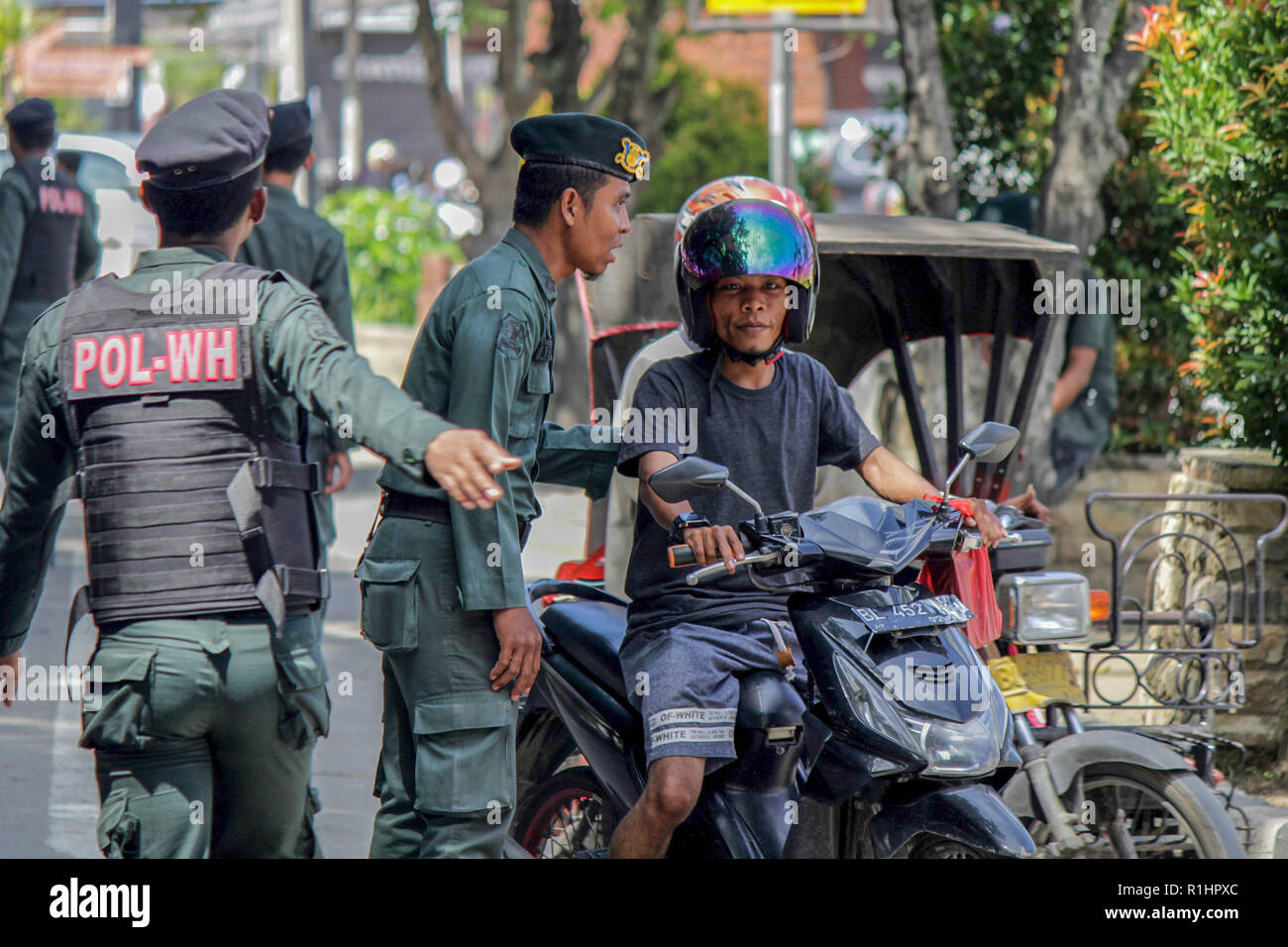 Die islamische Scharia Polizisten (Wilayatul Hisbah) stoppen ein Kraftfahrer einen Kurzschluß tragen während des routinemäßigen Razzien in Lhokseumawe. Die islamische Scharia Polizisten (Wilayatul Hisbah) bieten sarongs Für diejenigen, die die islamische Scharia durch Gewalt in der Stadt Lhokseumawe verletzt, Aceh ist die einzige Provinz in Indonesien mit der größten Bevölkerung von Muslimen in der Welt, der die islamische Scharia wie Ausschuss caning implementiert und die Durchführung von routinemäßigen Raids Für diejenigen, die Fest für Frauen und kurze Hosen für Männer gekleidet sind. Stockfoto