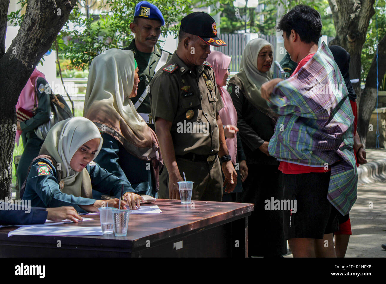 Die islamische Scharia Polizisten (Wilayatul Hisbah) gesehen, die Durchführung der Datenerhebung für diejenigen, die das Gesetz der Scharia durch Gewalt in der Stadt Lhokseumawe verletzt. Die islamische Scharia Polizisten (Wilayatul Hisbah) bieten sarongs Für diejenigen, die die islamische Scharia durch Gewalt in der Stadt Lhokseumawe verletzt, Aceh ist die einzige Provinz in Indonesien mit der größten Bevölkerung von Muslimen in der Welt, der die islamische Scharia wie Ausschuss caning implementiert und die Durchführung von routinemäßigen Raids Für diejenigen, die Fest für Frauen und kurze Hosen für Männer gekleidet sind. Stockfoto