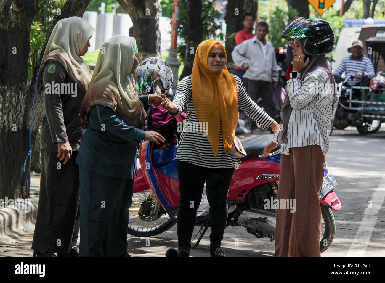 Die islamische Scharia Polizisten Wilayatul Hisbah) Anhalten eines Autofahrer feste Kleidung tragen während des routinemäßigen Razzien in Lhokseumawe. Die islamische Scharia Polizisten (Wilayatul Hisbah) bieten sarongs Für diejenigen, die die islamische Scharia durch Gewalt in der Stadt Lhokseumawe verletzt, Aceh ist die einzige Provinz in Indonesien mit der größten Bevölkerung von Muslimen in der Welt, der die islamische Scharia wie Ausschuss caning implementiert und die Durchführung von routinemäßigen Raids Für diejenigen, die Fest für Frauen und kurze Hosen für Männer gekleidet sind. Stockfoto