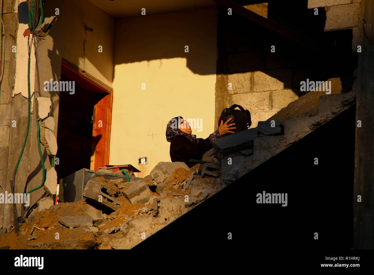 Eine Frau, die neben dem Schutt der Gebäude, die von der zionistischen Besatzung Flugzeuge während der Luftangriffe im Gazastreifen bombardiert wurde. Stockfoto