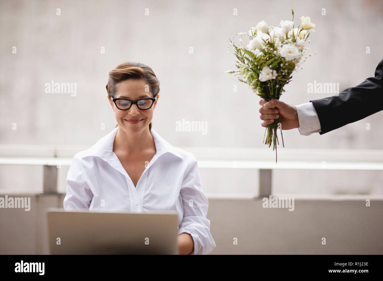 Geschäftsfrau, die Blumen bei der Arbeit. Stockfoto