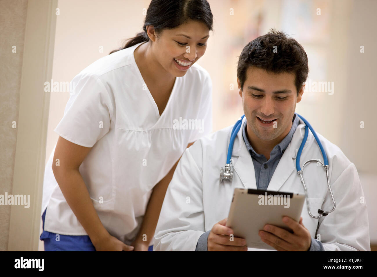 Junge weibliche Krankenschwester diskutieren stellt mit einem Arzt. Stockfoto