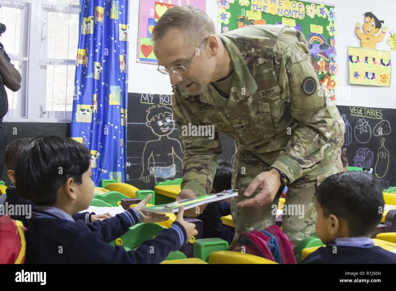 Generalmajor William Graham, der Yudh Abhyas 18 Force Commander, gibt Schulbedarf Kinder in Chaubattia militärische Station, Indien, Sept. 27, 2018 zur Schule. Während der Begehung, Graham sprach mit den Kindern über die Bedeutung der Bildung und dankte den Lehrern für ihre harte Arbeit. Dies wurde bei Yudh Abhyas 18, eine Übung, die die Bereitschaft und die Partnerschaft zwischen der US-amerikanischen und indischen Armeen zu verbessern. Stockfoto