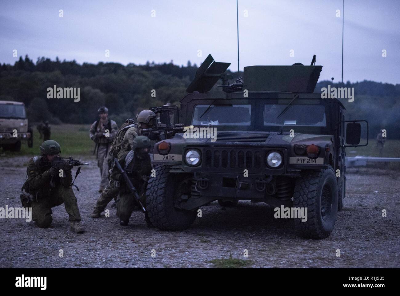 Us-Special Forces Soldaten zugeordnet 20 Special Forces Group (Airborne) und die Mitglieder der Litauischen Nationalen Verteidigung ehrenamtliche Kräfte (KASP) während der Übung Sabre Junction 2018 das Joint Multinational Readiness Center in Hohenfels, Deutschland, September 22, 2018 ein Raid leiten. Special Operations Forces arbeitete neben den KASP während Sabre Kreuzung 18 Irreguläre Kriegführung in Feind zu führen besetztes Gebiet der US-Armee 173rd Airborne Brigade zu unterstützen, wie sie landen in einem multinationalen gemeinsamen Umgebung ausgeführt. Stockfoto