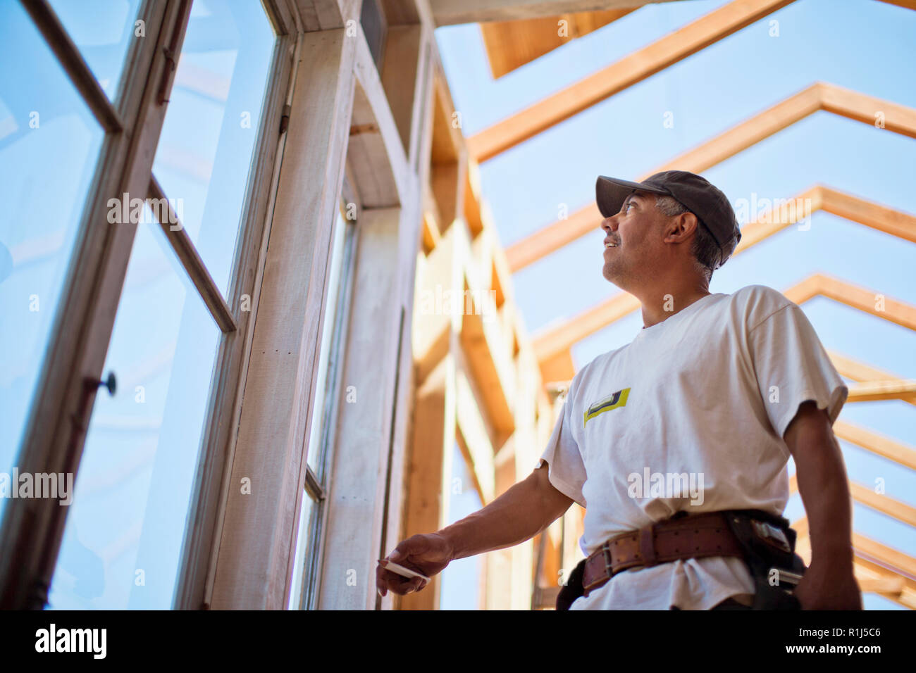 Im mittleren Alter Builder arbeiten an der Holz- Gestaltung eines Gebäudes. Stockfoto