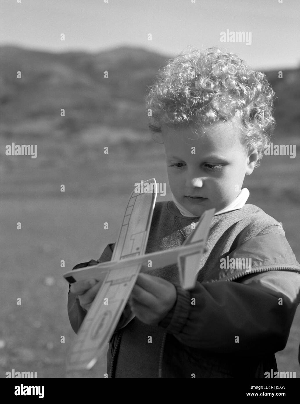 Kleiner Junge auf Modellflugzeug. Stockfoto