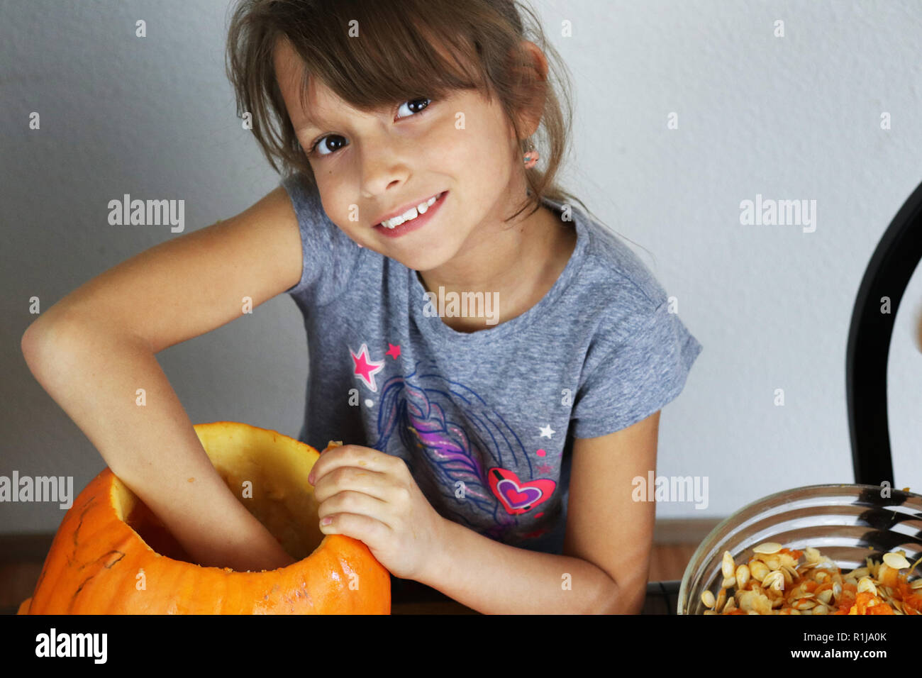 Kind Carving eine orange Kürbis während der Halloween Jahreszeit Stockfoto