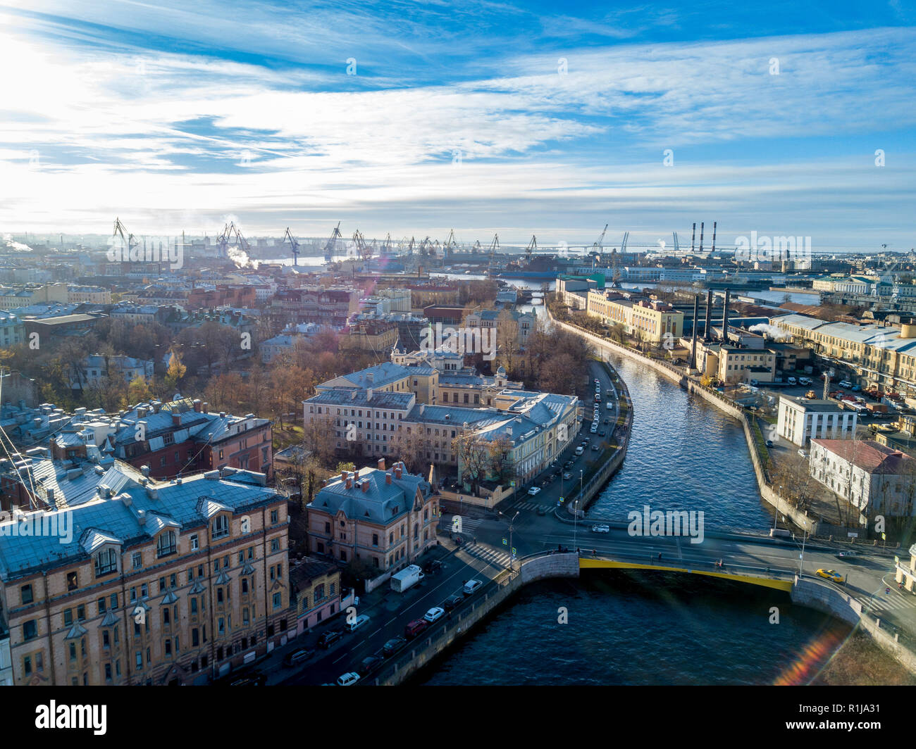 Antenne; drone Blick auf den Fluss Kanal im historischen Teil mit Brücken und alten Fassaden in der Nähe von embankment, Port mit Ladekränen und Werften Stockfoto