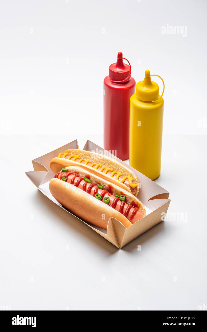 Nahaufnahme der würzigen Würstchen mit Senf und Ketchup auf Weiß Stockfoto