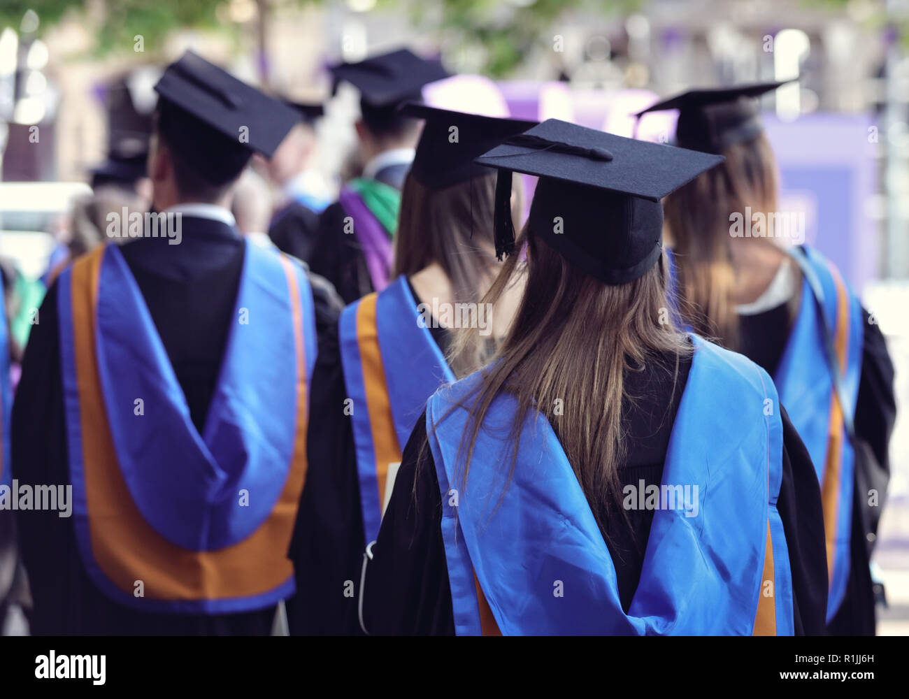 Die Absolventen an der Universität Abschlussfeier tragen mortarboard und Kleid Stockfoto
