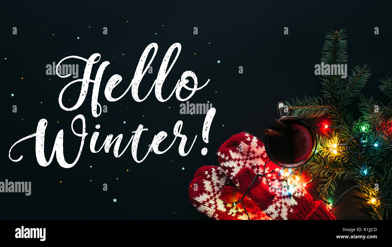 Ansicht von Glühwein in Schale, Garland und Gruß Hallo Winter auf schwarz, Weihnachten Konzept isoliert Stockfoto