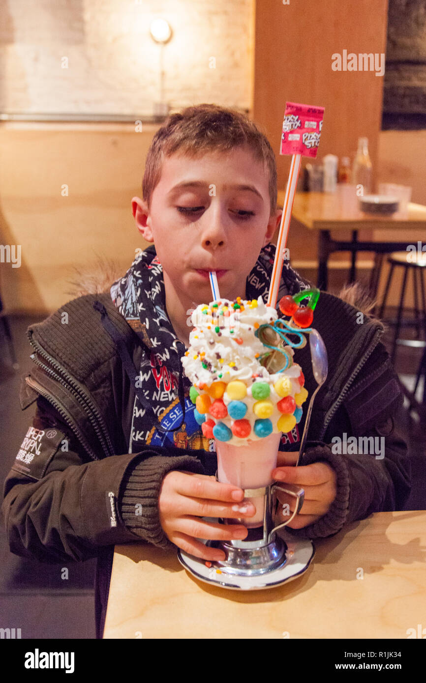 9 Jahre alter Junge mit einem sauren Power Black Cherry Crazy Shake Milchshake, Schwarz tippen, Ludlow Street, Lower East Side, New York, Vereinigte Staaten von Amerika. Stockfoto