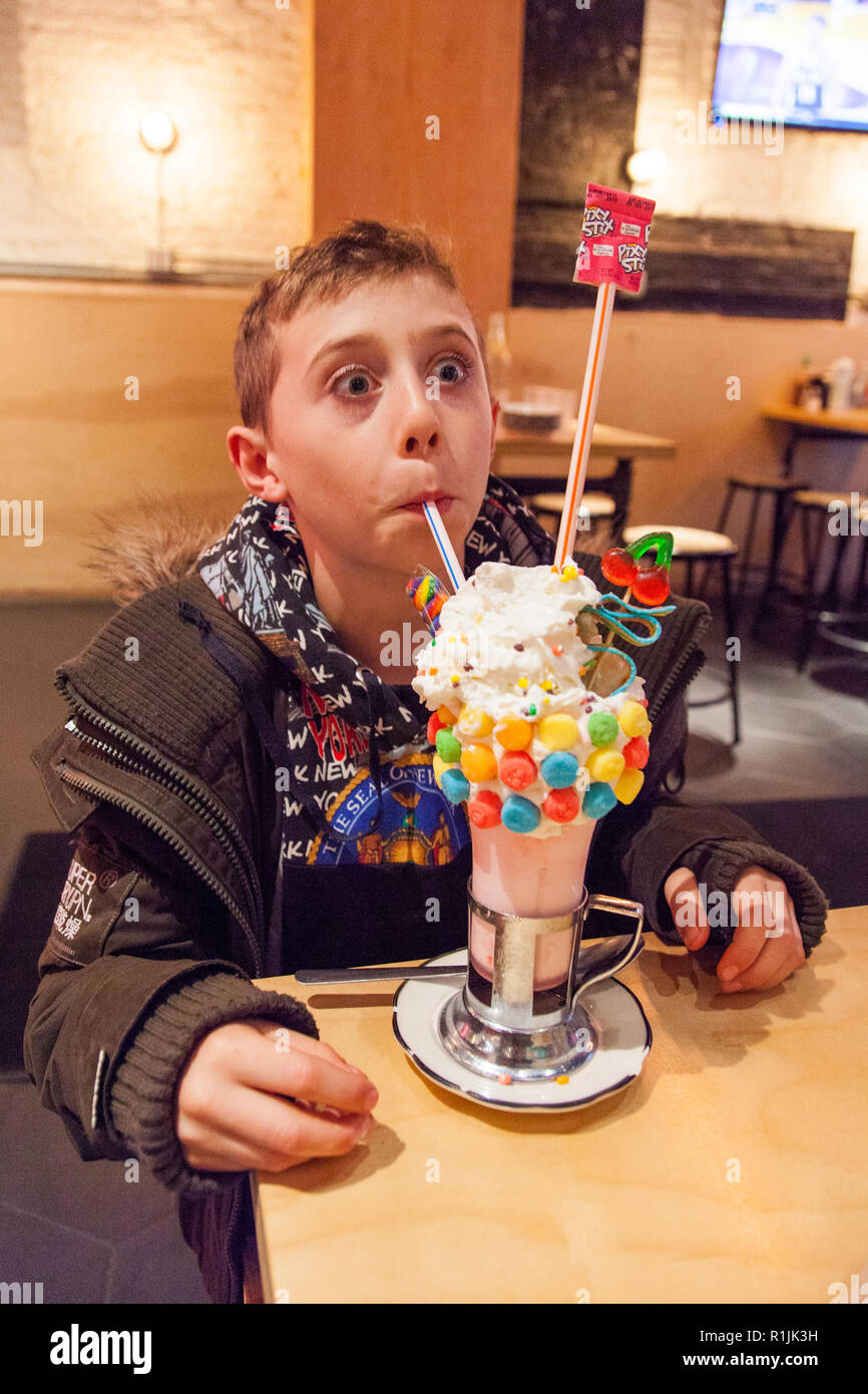 9 Jahre alter Junge mit einem sauren Power Black Cherry Crazy Shake Milchshake, Schwarz tippen, Ludlow Street, Lower East Side, New York, Vereinigte Staaten von Amerika. Stockfoto