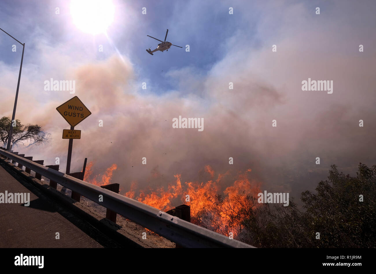 Simi Valley, Kalifornien, USA. 12. Nov 2018. Ein Hubschrauber bereitet ein Tropfen auf die wildfire in der Nähe einer Autobahn in Simi Valley, Kalifornien, in den Vereinigten Staaten an November 12, 2018 zu machen. Das Feuer in Südkalifornien weitere Wohnungen zu zerstören. (Xinhua / Zhao Hanrong) (jmmn) Quelle: Xinhua/Alamy leben Nachrichten Stockfoto