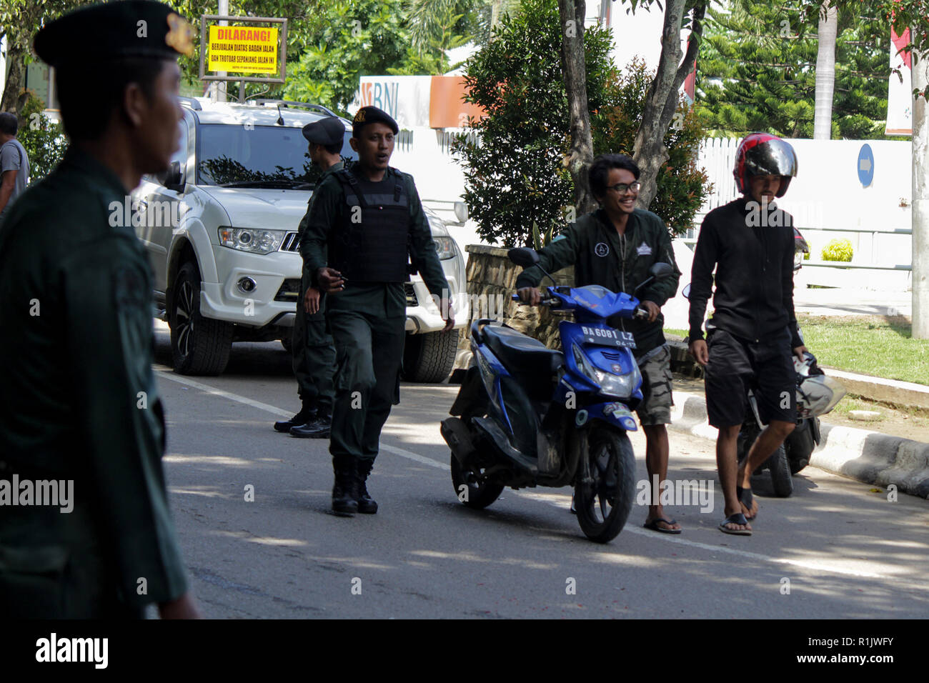 Lhokseumawe, Aceh, Indonesien. 13 Nov, 2018. Die islamische Scharia Polizeioffizier (Wilayatul Hisbah) gesehen stoppen ein Kraftfahrer einen Kurzschluß tragen während des routinemäßigen Razzien in Lhokseumawe. islamische Scharia Polizisten (Wilayatul Hisbah) bieten sarongs Für diejenigen, die die islamische Scharia durch Gewalt in der Stadt Lhokseumawe verletzt, Aceh ist die einzige Provinz in Indonesien mit der größten Bevölkerung von Muslimen in der Welt, der die islamische Scharia wie Ausschuss caning implementiert und die Durchführung von routinemäßigen Raids Für diejenigen, die Fest für Frauen und kurze Hosen für Männer gekleidet sind. (Credit Ima Stockfoto