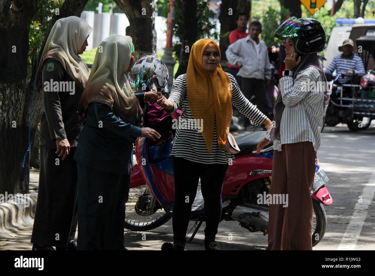 Lhokseumawe, Aceh, Indonesien. 13 Nov, 2018. Die islamische Scharia Polizisten Wilayatul Hisbah) Anhalten eines Autofahrer feste Kleidung tragen während des routinemäßigen Razzien in Lhokseumawe. islamische Scharia Polizisten (Wilayatul Hisbah) bieten sarongs Für diejenigen, die die islamische Scharia durch Gewalt in der Stadt Lhokseumawe verletzt, Aceh ist die einzige Provinz in Indonesien mit der größten Bevölkerung von Muslimen in der Welt, der die islamische Scharia wie Ausschuss caning implementiert und die Durchführung von routinemäßigen Raids Für diejenigen, die Fest für Frauen und kurze Hosen für Männer gekleidet sind. Stockfoto