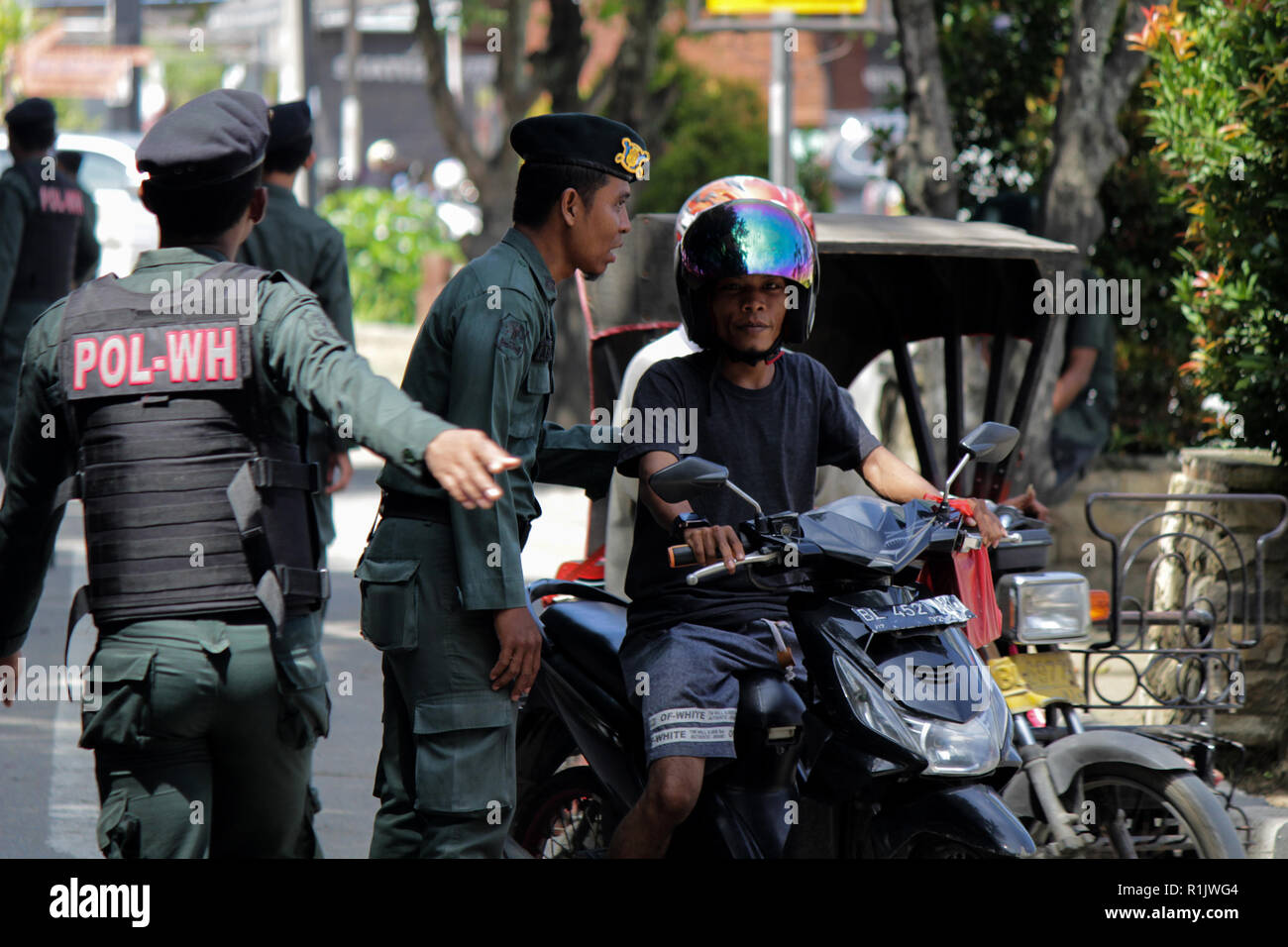 Lhokseumawe, Aceh, Indonesien. 13 Nov, 2018. Die islamische Scharia Polizisten (Wilayatul Hisbah) gesehen werden stoppen ein Kraftfahrer einen Kurzschluß tragen während des routinemäßigen Razzien in Lhokseumawe. islamische Scharia Polizisten (Wilayatul Hisbah) bieten sarongs Für diejenigen, die die islamische Scharia durch Gewalt in der Stadt Lhokseumawe verletzt, Aceh ist die einzige Provinz in Indonesien mit der größten Bevölkerung von Muslimen in der Welt, der die islamische Scharia wie Ausschuss caning implementiert und die Durchführung von routinemäßigen Raids Für diejenigen, die Fest für Frauen und kurze Hosen für Männer gekleidet sind. (Credi Stockfoto