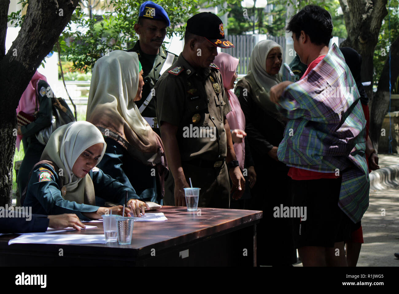 Lhokseumawe, Aceh, Indonesien. 13 Nov, 2018. Die islamische Scharia Polizisten (Wilayatul Hisbah) gesehen, die Durchführung der Datenerhebung für diejenigen, die das Gesetz der Scharia durch Gewalt in der Stadt Lhokseumawe. islamische Scharia Polizisten (Wilayatul Hisbah) verletzt bieten sarongs Für diejenigen, die die islamische Scharia durch Gewalt in der Stadt Lhokseumawe verletzt, Aceh ist die einzige Provinz in Indonesien mit der größten Bevölkerung von Muslimen in der Welt, der die islamische Scharia wie Ausschuss caning implementiert und die Durchführung von routinemäßigen Raids Für diejenigen, die Fest für Frauen und Shorts bekleidet sind fo Stockfoto