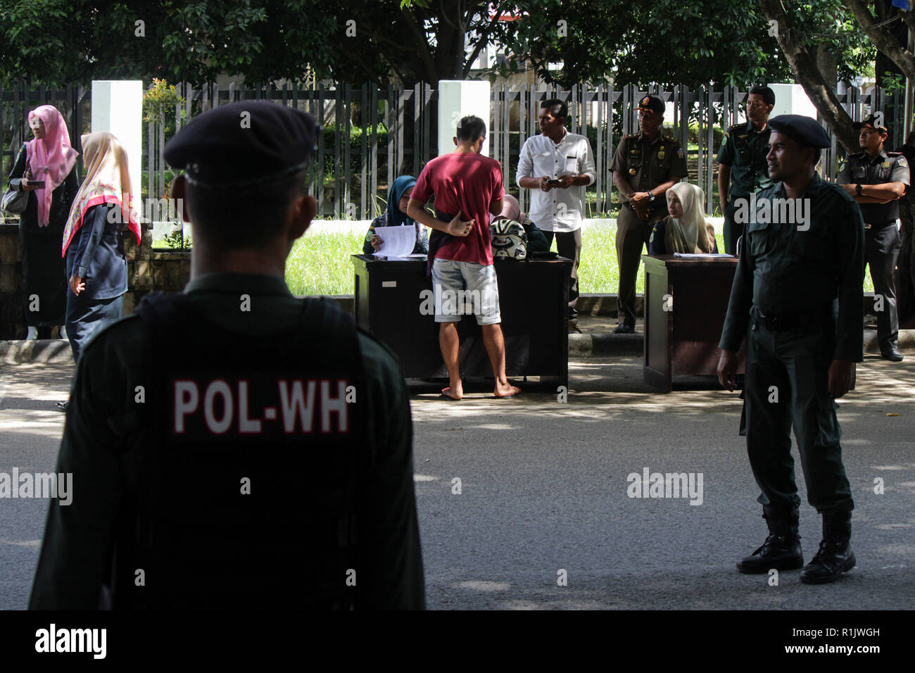 Lhokseumawe, Aceh, Indonesien. 13 Nov, 2018. Die islamische Scharia Polizisten (Wilayatul Hisbah) gesehen, die Durchführung der Datenerhebung für diejenigen, die das Gesetz der Scharia durch Gewalt in der Stadt Lhokseumawe. islamische Scharia Polizisten (Wilayatul Hisbah) verletzt bieten sarongs Für diejenigen, die die islamische Scharia durch Gewalt in der Stadt Lhokseumawe verletzt, Aceh ist die einzige Provinz in Indonesien mit der größten Bevölkerung von Muslimen in der Welt, der die islamische Scharia wie Ausschuss caning implementiert und die Durchführung von routinemäßigen Raids Für diejenigen, die Fest für Frauen und Shorts bekleidet sind fo Stockfoto