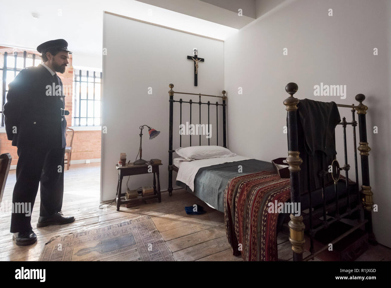 London, Großbritannien. 13. November 2018. Ein Mitarbeiter, als Gefängniswärter posieren, in Ruth Ellis' Gefängniszelle. Vorschau von "Froh, dass ich es Es ist, eine neue Arbeit von der irischen Künstlerin Christina Reihill in Bermondsey Project Space. Die interaktiven Kunstwerk betrachtet das Leben und den Tod von Ruth Ellis, die letzte Frau in Großbritannien gehängt werden, nachdem sie ihren Liebhaber erschossen, Rennfahrer, David Blakely 1955. Auf dem Display sind Interpretation des Künstlers von Ruth Ellis' Gefängniszelle, einschließlich Möbel und Requisiten, die hängenden Zimmer zusammen mit einem Video anzeige der Künstler im Gespräch. Credit: Stephen Chung/Alamy leben Nachrichten Stockfoto