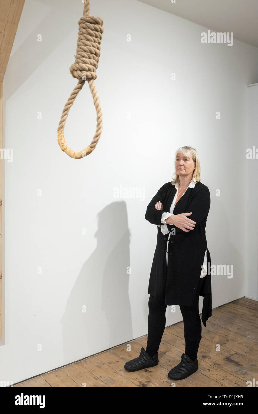 London, Großbritannien. 13. November 2018. Künstlerin Christina Reihill stellt mit einem Henker Schlinge. Vorschau von "Froh, dass ich es Es ist, eine neue Arbeit von der irischen Künstlerin Christina Reihill in Bermondsey Project Space. Die interaktiven Kunstwerk betrachtet das Leben und den Tod von Ruth Ellis, die letzte Frau in Großbritannien gehängt werden, nachdem sie ihren Liebhaber erschossen, Rennfahrer, David Blakely 1955. Auf dem Display sind Interpretation des Künstlers von Ruth Ellis' Gefängniszelle, einschließlich Möbel und Requisiten, die hängenden Zimmer zusammen mit einem Video anzeige der Künstler im Gespräch. Credit: Stephen Chung/Alamy leben Nachrichten Stockfoto