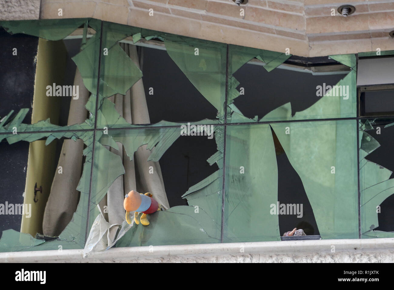 Gaza, Gaza, Gaza. 13 Nov, 2018. Spielzeuge sind auf der Windows gesehen nach der israelischen Besatzungstruppen ein Gebäude in der Morgendämmerung in Gaza Stadt. Credit: Mohamed Zarandah/SOPA Images/ZUMA Draht/Alamy leben Nachrichten Stockfoto