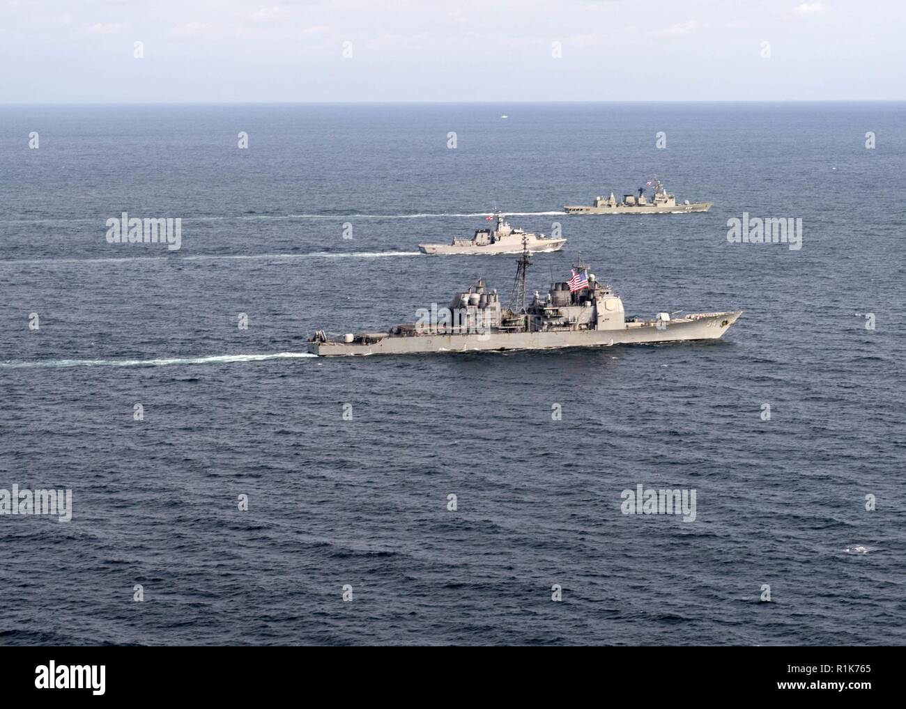 Die US-Marine geführte-missile Cruiser USS Antietam (CG54), der Royal Thai Navy offshore Patrol vessel HTMS Krabi (OPV 551) und Royal Thai Navy Fregatte HTMS Taksin (FFG422) ein taktisches Manöver Verhalten während einer kooperativen Bereitstellung, East China Sea 9 Oktober, 2018. Die USS Antietam freut sich auf die US-Flotte 7 Bereich für Maßnahmen zur Erhöhung der Sicherheit und Stabilität in der indopazifischen Region bereitgestellt. Stockfoto