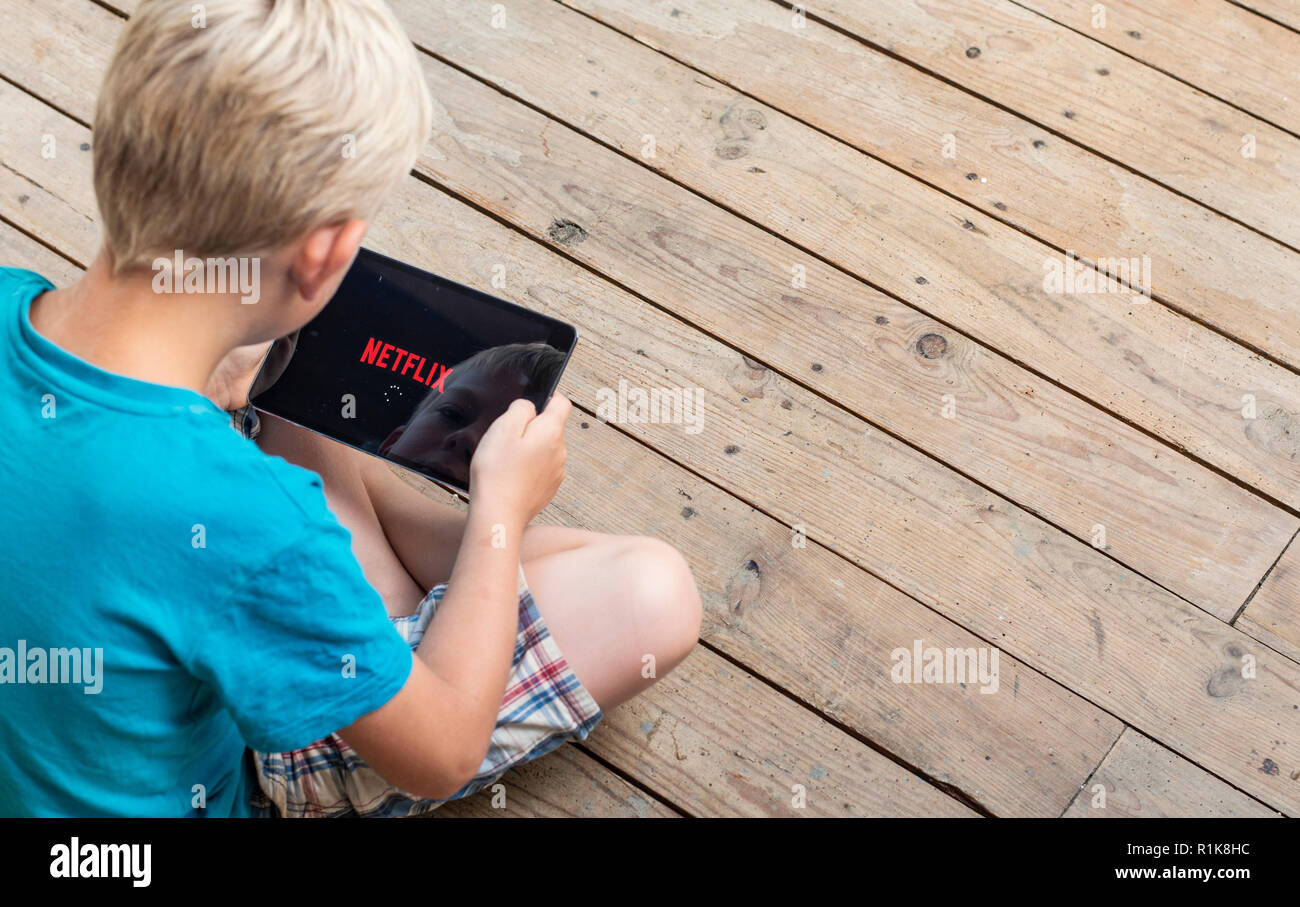 Junge beobachten Netflix auf seinem ipad Stockfoto