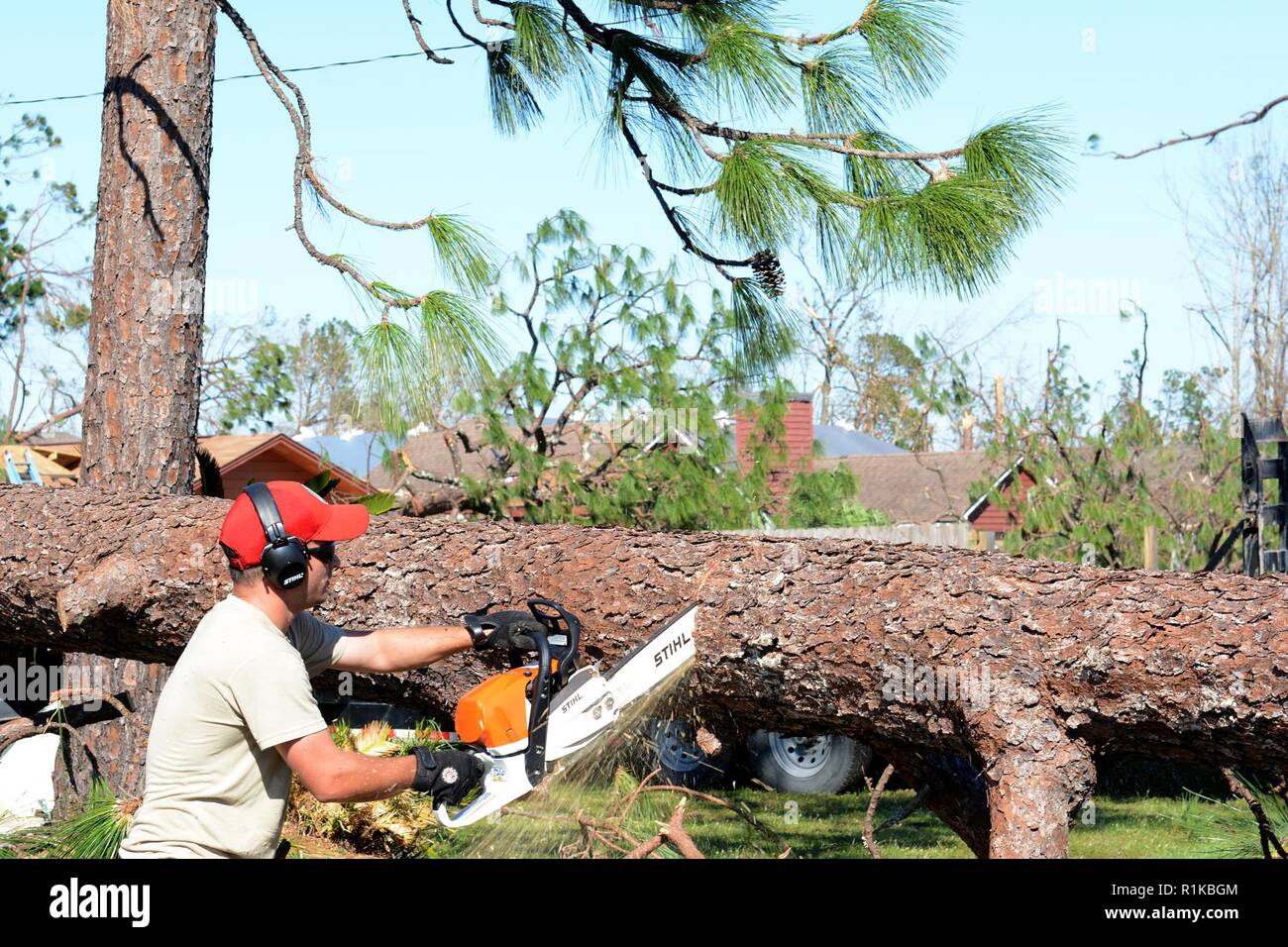 Staff Sgt. Alex Spano, elektrische Facharbeiter aus der 202. Geben Sie der Camp Blanding, Fla., verwendet eine Kettensäge zu helfen, einen gefallenen Baum sperren einer Wohnstraße in Eschwege, Fla., Okt. 13, 2018 klar. Hurricane Michael links schwere Schäden im gesamten Panama City Bereich, und die 202 war auf für ihre Sachkenntnis in Route clearing genannt. Stockfoto