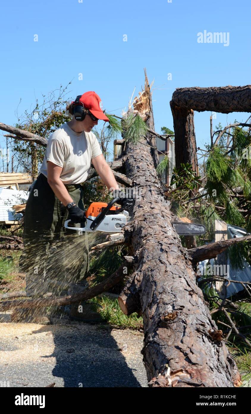 Staff Sgt. Colleen Curren, Strukturen aus der 202. Geben Sie der Camp Blanding, Fla. Facharbeiter, Kettensägen durch einen umgestürzten Baum auf Debi Straße im Bayou George Bereich von Panama City Okt. 14, 2018. Die GEBEN Sie auf Für ihr Know-how in der effizienten Route clearing genannt nach dem Hurrikan Michael durch kamen. Stockfoto