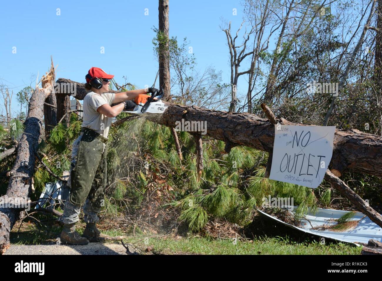Staff Sgt. Colleen Curren, Strukturen aus der 202. Geben Sie der Camp Blanding, Fla. Facharbeiter, Kettensägen durch einen umgestürzten Baum auf Debi Straße im Bayou George Bereich von Panama City Okt. 14, 2018. Die GEBEN Sie auf Für ihr Know-how in der effizienten Route clearing genannt nach dem Hurrikan Michael durch kamen. Stockfoto