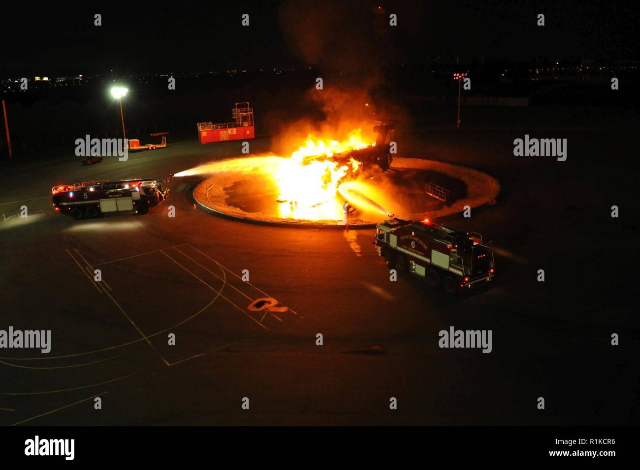 Löschfahrzeuge von der 374 Bauingenieur Squadron Schlacht ein Brand während einer live Feuer Demonstration, Oktober 12, 2018, Yokota Air Base, Japan. Die Brennen aktiviert die Zuschauer von der lokalen Gemeinschaft Yokota Feuerwehrmänner in Aktion zu sehen. Stockfoto