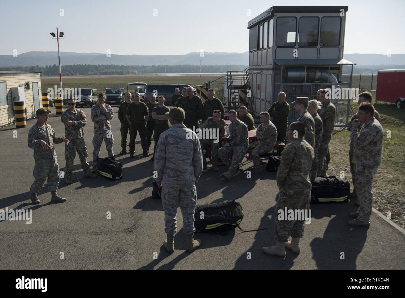 Us Air Force Staff Sgt. Robert Welborn (links), 435Th Konstruktion und Training Squadron Feuerwehr und Kontingenz Ausbildung Instructor, debriefings Lettische und litauische Luftwaffen Feuerwehrmänner nach einem Tag der Bereich Ausbildung während der US-Streitkräfte in Europa NATO Feuerwehrmann Partnerschaft Kurs auf der Air Base Ramstein, Deutschland, Okt. 10, 2018. Etwa 20 Lettische und litauische Luftwaffen Feuerwehrmänner in dem 5-tägigen Kurs, nahm auf vertraut zu NATO-Verbündeten mit Crash und Brand Verfahren, sodass Partner Nationen zusammen in jeder Situation zu arbeiten. Stockfoto