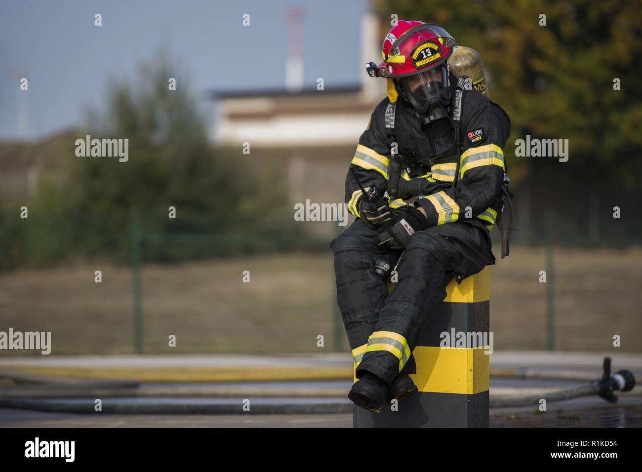 Us Air Force Staff Sgt. Frank Butler, 435Th Konstruktion und Training Squadron Feuerwehr und Kontingenz Ausbildung Instructor, sitzt, während für eine Simulation während der US-Streitkräfte in Europa NATO Feuerwehrmann Partnerschaft Kurs auf der Air Base Ramstein, Deutschland, Okt. 10, 2018 zu beginnen. Butler zur Verfügung Crash und Brand Verfahren Leitlinien für die Studierenden während des Löschens simuliert Brände. Stockfoto